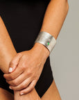 Reptilia Maxima silver cuff with green cabochon, worn on wrist.
